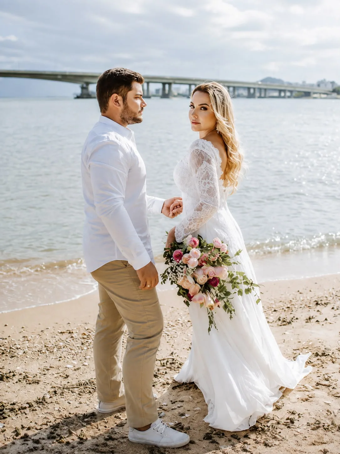 Casal na beira da baía com a ponte ao fundo